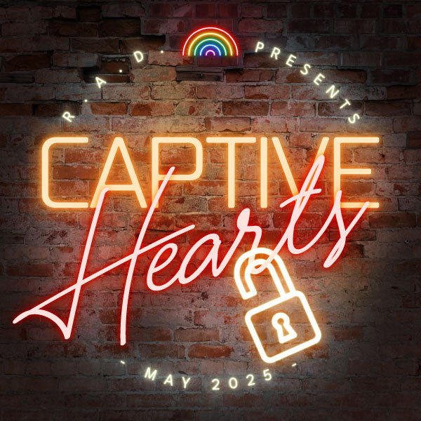 A neon sign on a dark brick wall. The sign says “Captive Hearts” in orange and red. An unlocked yellow lock hangs off the bottom of “Hearts”. Text is curved around the top and says "R. A. D. Presents" in white neon font. A neon rainbow glows in between RAD and Presents. Text is along the bottom and says "- May 2025 -" in white neon font.

