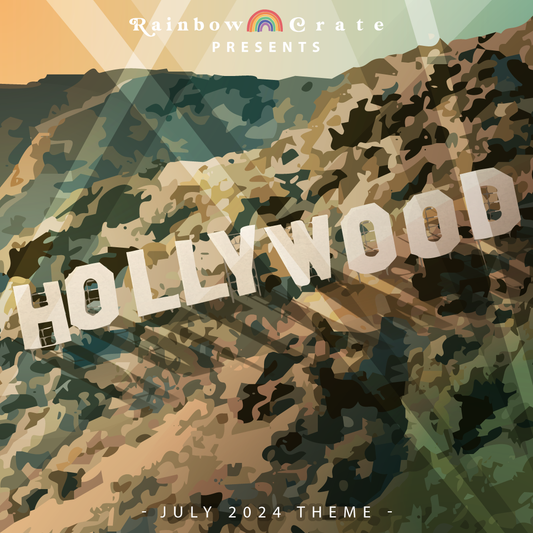 A graphic of a desert hill at sunset. Sprawled along it is the word HOLLYWOOD, mimicking the famous sign. At the top is "Rainbow Crate" with a rainbow in between the words and "presents" underneath. At the very bottom it reads "- July 2024 Theme -" in all caps. 