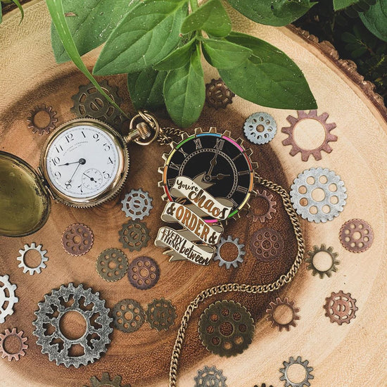 Our Timekeeper pin as described above surrounded by flora and metal gears